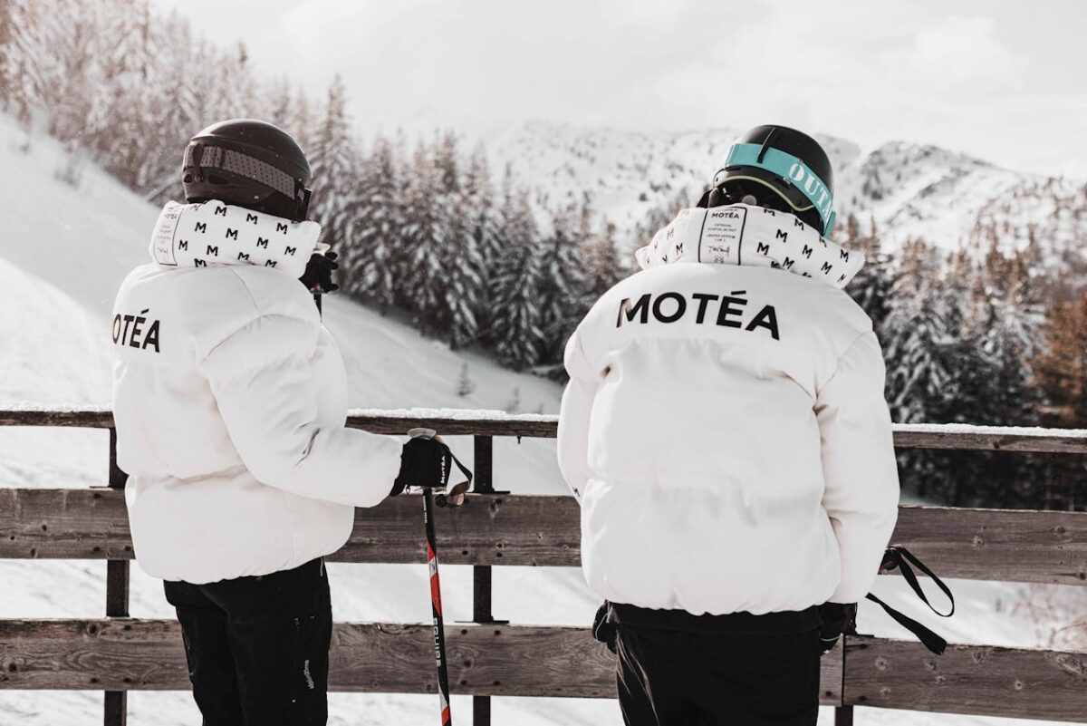 Two skiers in white jackets overlooking a snowy landscape in Brezovica, Serbia.